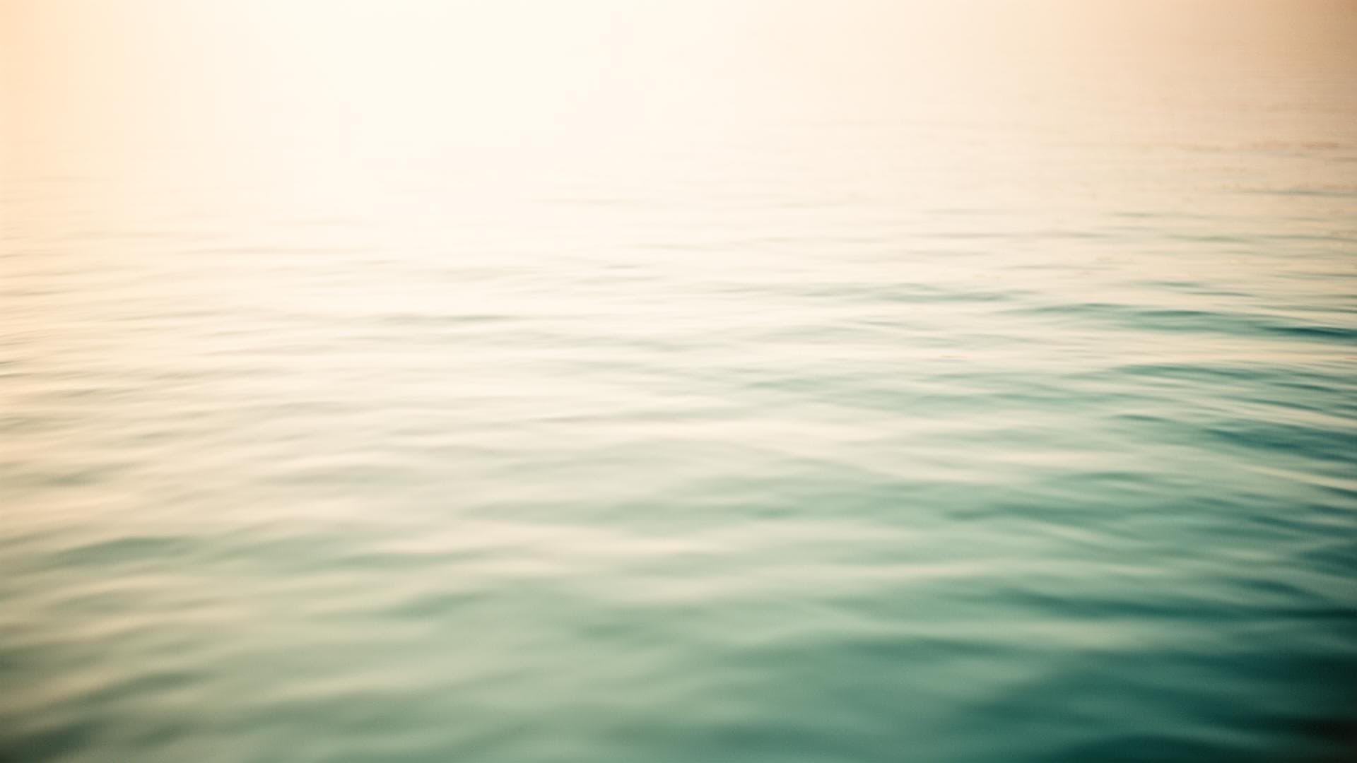 Calm water surface in soft ivory and teal light